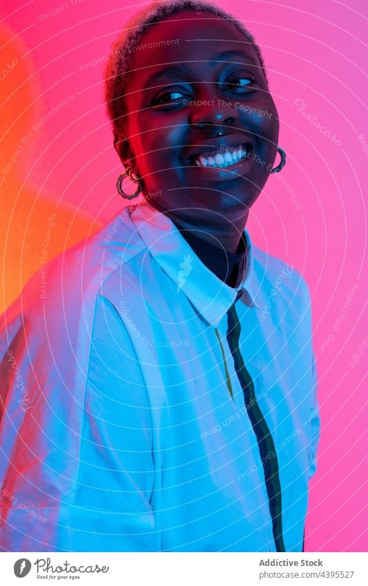 Cheerful black woman in studio with neon lights cheerful model smile style trendy colorful female african american ethnic content delight happy individuality
