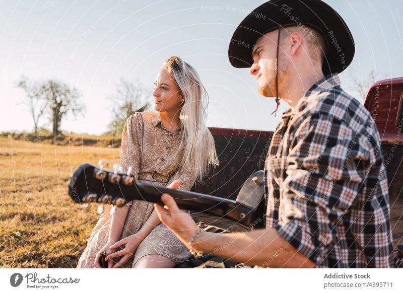Couple with guitar sitting in vintage pickup truck car couple play countryside pick up retro music together cowboy romantic boyfriend vehicle relationship