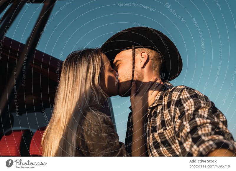 Couple in love kissing near car couple blue sky romantic evening summer relationship together affection cowboy tender young freedom bonding close boyfriend