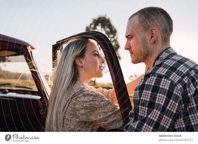 Tender couple near vintage car in countryside retro love romantic evening touch face tender old fashioned summer nature sunset together style red relationship