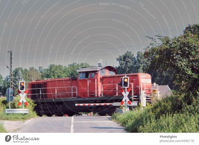 Red railway at a level crossing with barrier and warning light Railroad Railroad crossing Control barrier Light Warning light St. Andrew's Cross Driving