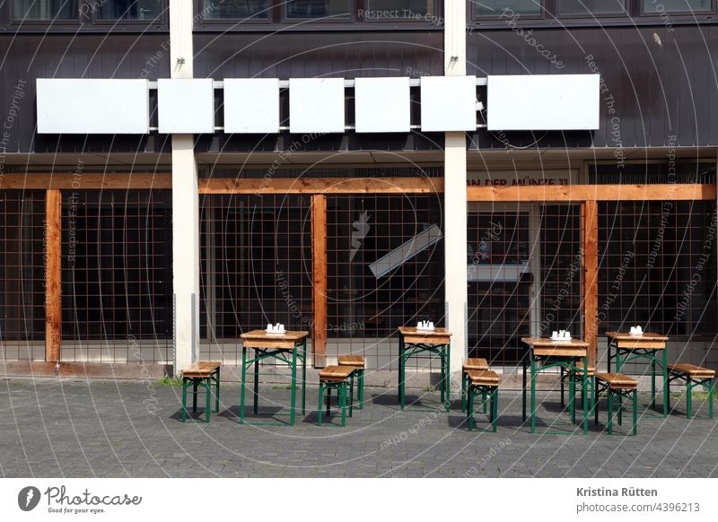outdoor gastronomy takes over the space in front of an abandoned shop Terrace Beer table beer benches beer set Gastronomy Beer garden Neon sign Closed Empty