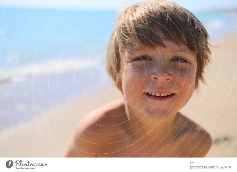 face of a beautiful child smiling at the camera on the seashore positive emotion smile Ocean Beach Individual Isolated Single Abstract Movement Flow