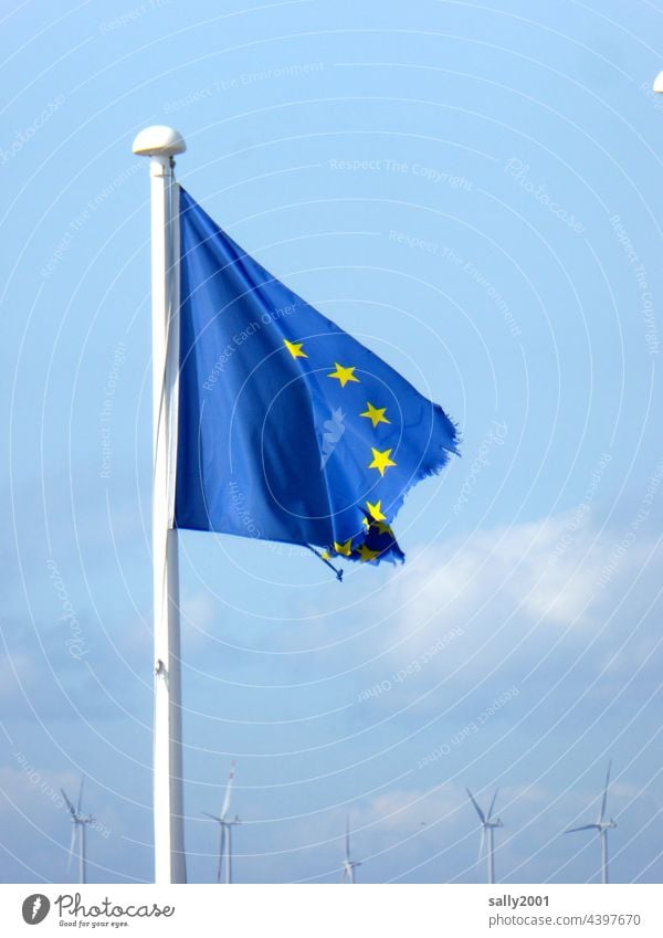 Dissolving European flag in front of wind farm.... European Union Broken Wind Disheveled Flag EU Blue Politics and state Blow Symbols and metaphors Sign brexite