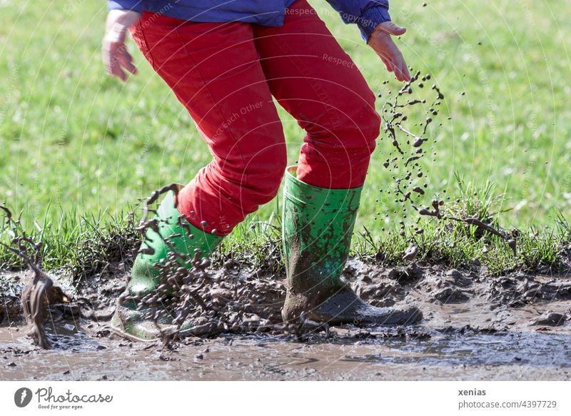 Jumping into the mud with green rubber boots and red pants is fun Rubber boots slush Inject Dirty Green Red Pants spill Joy Puddle Playing Autumn Mud Brown