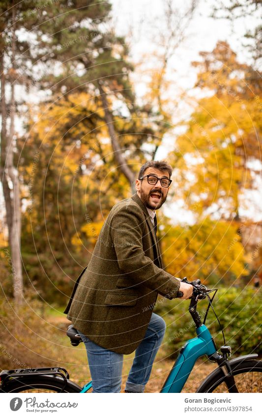 Young man with electric bicycle in the autumn park young nature lifestyle outdoor activity color ride summer bike day leisure people ebike travel sport city