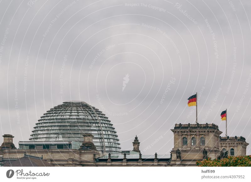 Germany flag on the Reichstag in Berlin during upcoming storm - stormy times German flag black-red-gold Flag Blow Politics and state Landmark Wrinkles Yellow