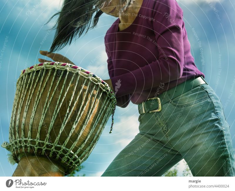 A woman drums djembe Woman Drum Drum set Music Rhythm Drummer tool Beat Concert good-looking Sound Practice Musician Live Sky Clouds Blue Blue sky Jeans