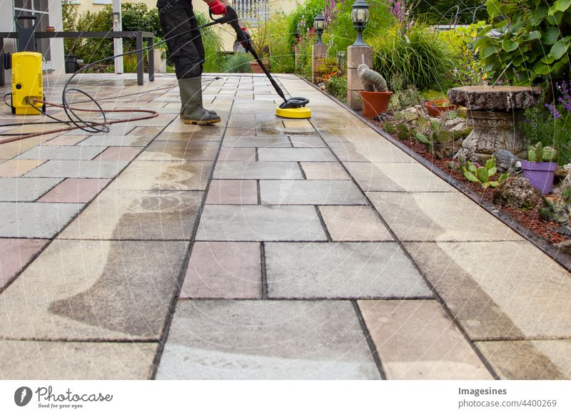 Spring cleaning. Clean patio slabs with the high-pressure cleaner. terrace tiles high pressure cleaners Cleaning Working man Rubber boots Ground Outdoors