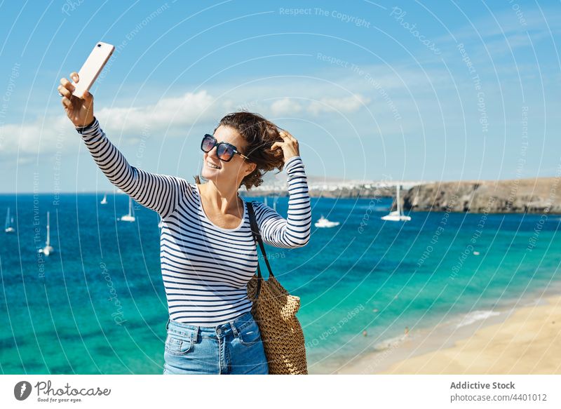 Female traveler taking selfie near sea woman beach smile summer resort rest smartphone vacation fuerteventura spain canary islands female gadget device happy