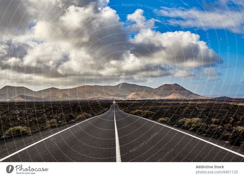 Asphalt road in valley near mountains field morning nature asphalt landscape sky cloudy fuerteventura spain canary islands highway route travel trip straight