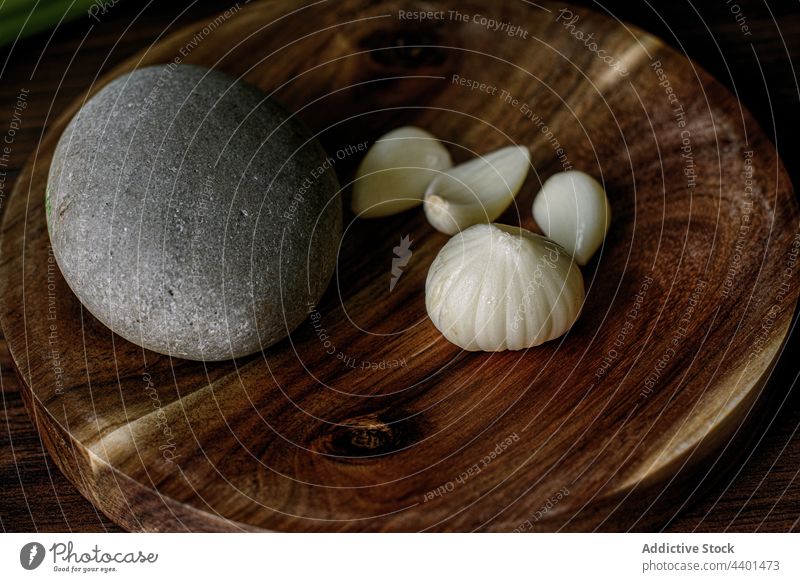 Fresh garlic in grinding mortar on table head clove fresh ripe ingredient wooden stone pebble culinary nutrition organic food kitchen cuisine raw aromatic