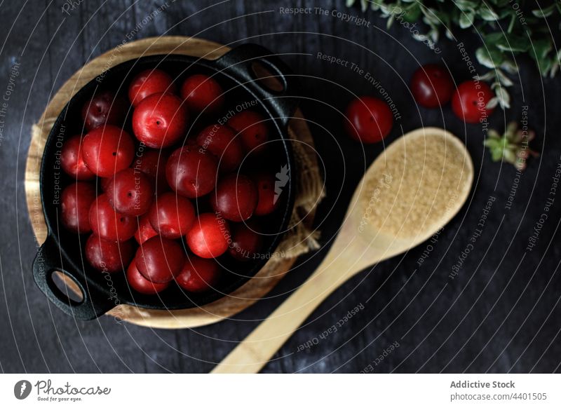 Ripe plums in bowl on table with spoon of sugar ripe fresh pile ingredient sweet delicious serve yummy gourmet tasty wooden recipe organic natural culinary