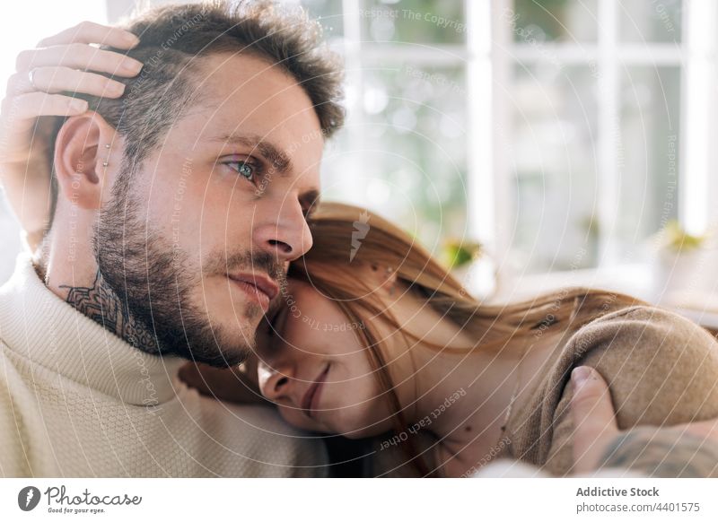 Dreamy woman caressing bearded husband at home couple embrace love relationship romantic dreamy tattoo portrait wife friendly sincere contemplate reflective