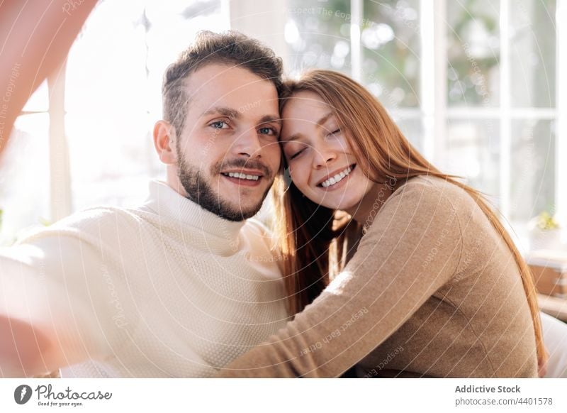 Smiling couple taking selfie in house room cheerful relationship love moment memory romantic home portrait friendly self portrait sincere girlfriend enjoy