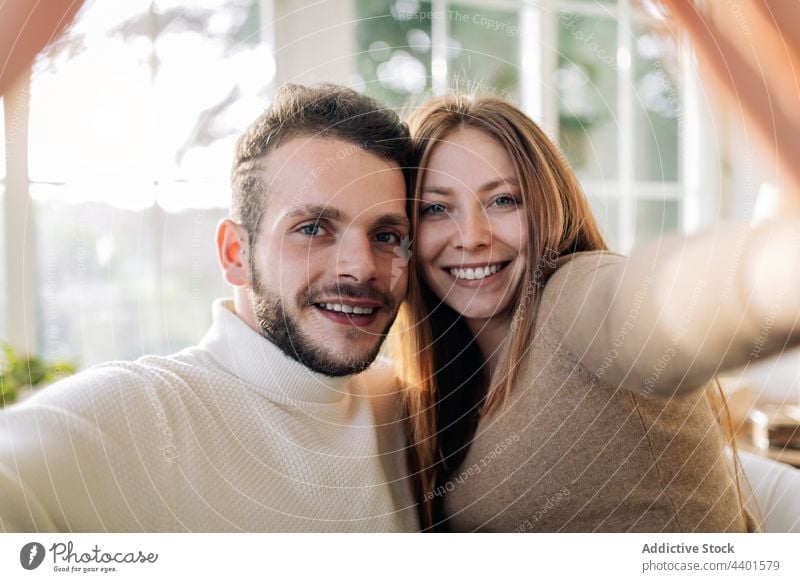 Smiling couple taking selfie in house room cheerful relationship love moment memory romantic home portrait friendly self portrait sincere girlfriend enjoy
