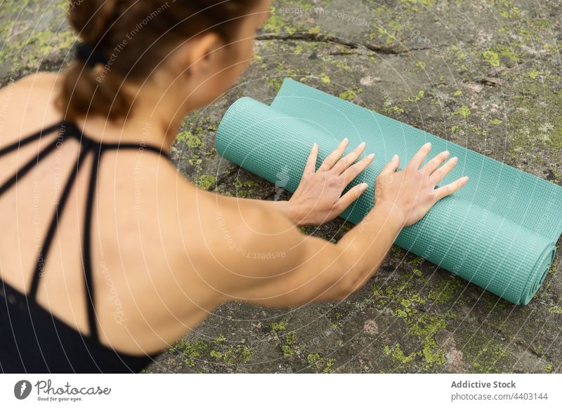 Female laying yoga mat on stone woman prepare unroll nature start session practice female healthy lifestyle young wellness energy wellbeing activity rock