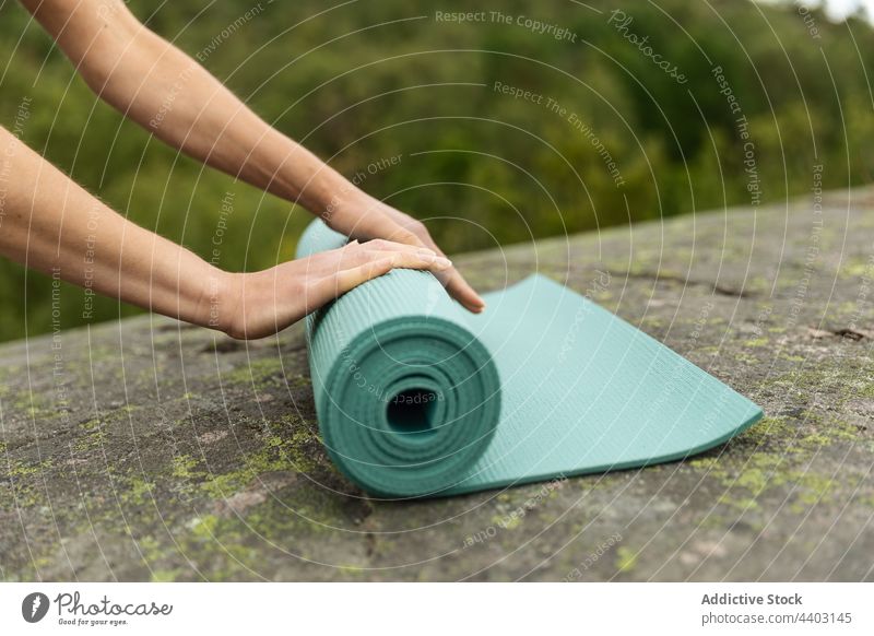 Female laying yoga mat on stone woman prepare unroll nature start session practice female healthy lifestyle young wellness energy activity rock barefoot