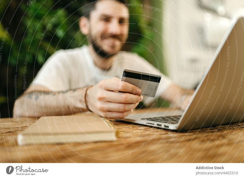 Man making payment with plastic card during online shopping man laptop purchase order shopper e commerce customer consume store buyer transaction credit card