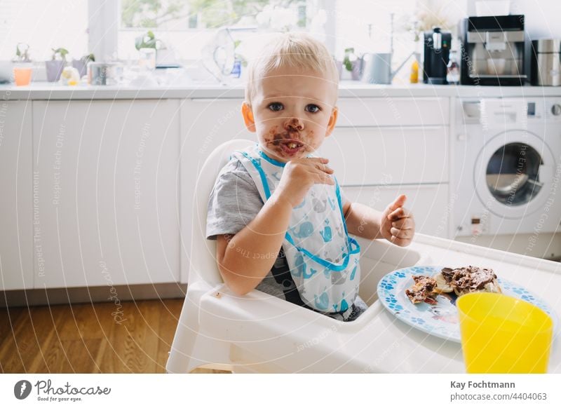 Adorable toddler with face covered in chocolate 12-23 months addiction adorable baby blond hair blue eyes candy caucasian caucasian ethnicity cheerful child