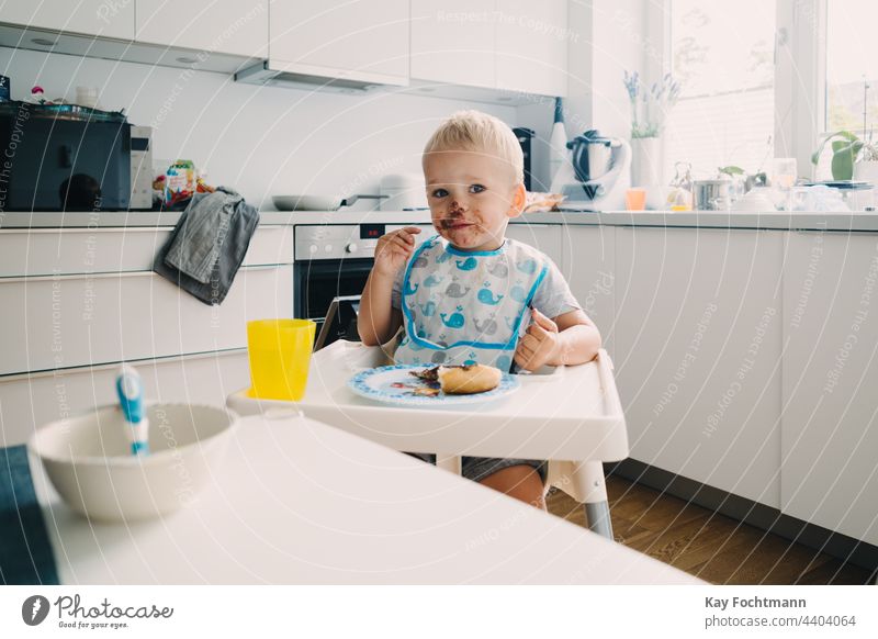 Adorable toddler with face covered in chocolate 12-23 months addiction adorable baby blond hair blue eyes candy caucasian caucasian ethnicity cheerful child