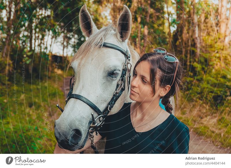 Young woman preparing to become a riding instructor taking care and talking to a horse on a hot autumn day girl animal nature young sport rider horseback