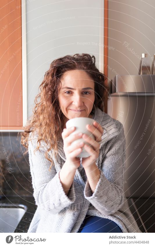 Woman in the kitchen taking an infusion woman healthy beautiful drinking female interior sitting home indoor morning breakfast bowl lifestyle attractive organic