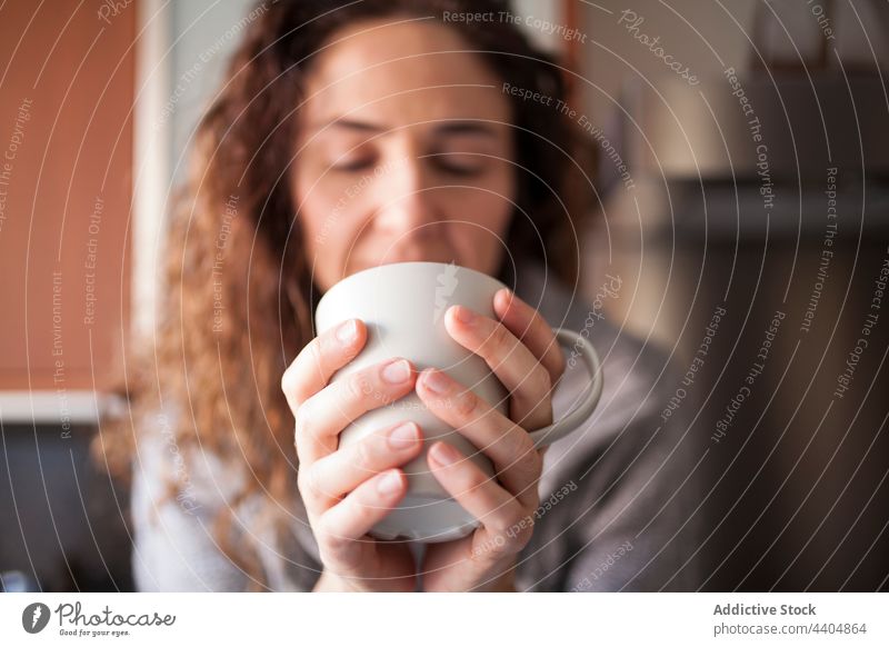 Woman in the kitchen taking an infusion woman healthy beautiful drinking female interior sitting home indoor morning breakfast bowl lifestyle attractive organic