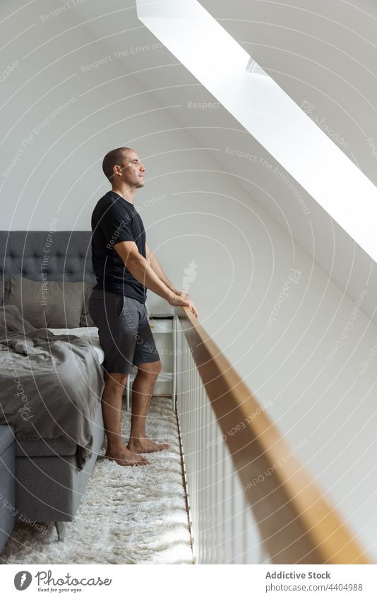 Man stretching after awakening in bedroom man morning home warm up wake up calm early male stand energy peaceful body contemplating tranquil domestic apartment