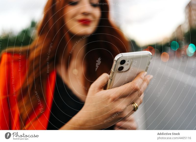 Redhead woman browsing on smartphone in city social media orange suit vibrant female mobile gadget device red hair redhead ginger using communicate internet