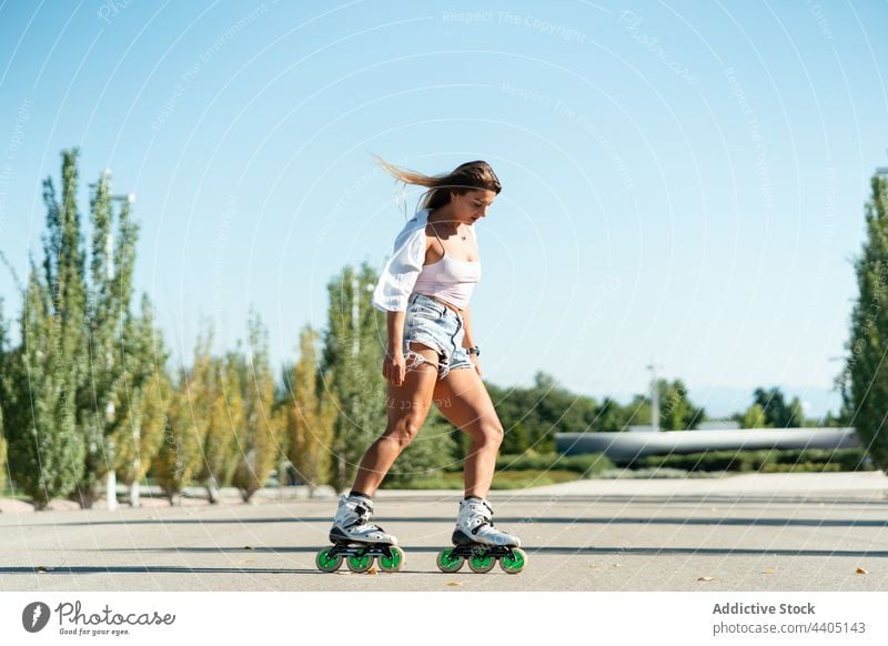 Woman in rollerblades and showing stunt woman trick equilibrium skater summer wheel street female activity practice sunny sunlight summertime road fit urban
