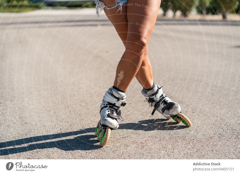anonymous woman in rollerblades and showing stunt trick equilibrium skater summer wheel street female activity practice sunny sunlight summertime legs body part