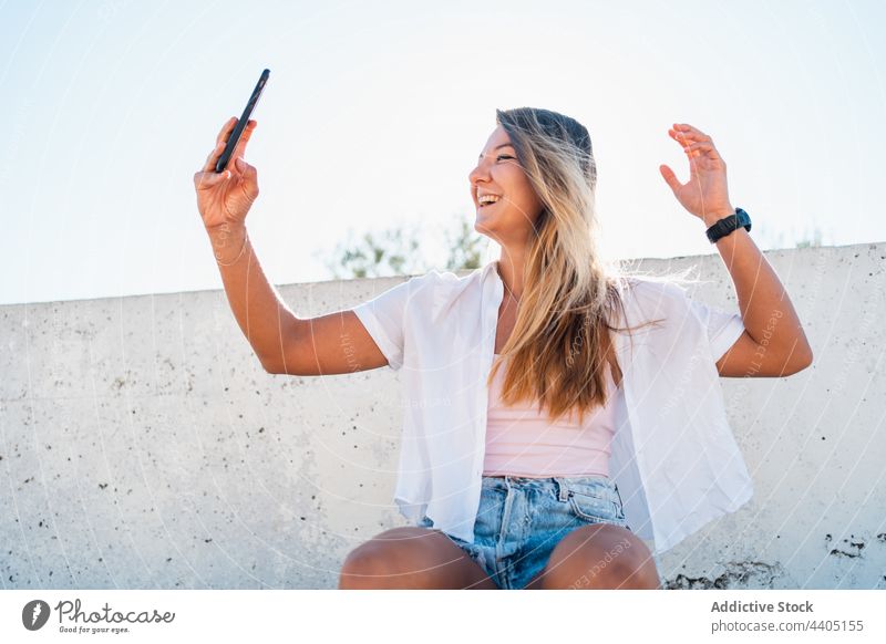 Smiling woman taking selfie in street smartphone city summer self portrait moment female happy cheerful memory mobile device smile cellphone take photo using