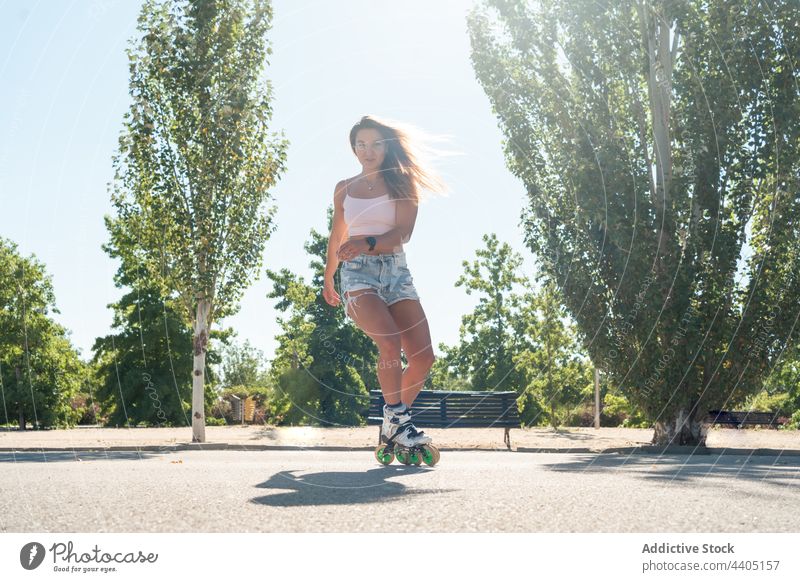 Woman in rollerblades and showing stunt woman trick equilibrium skater summer wheel street female activity practice sunny sunlight summertime road fit urban