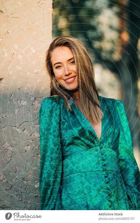 Happy woman in stylish green dress in city trendy fashion style outstretch carefree freedom female outfit summer urban charming street smile enjoy feminine