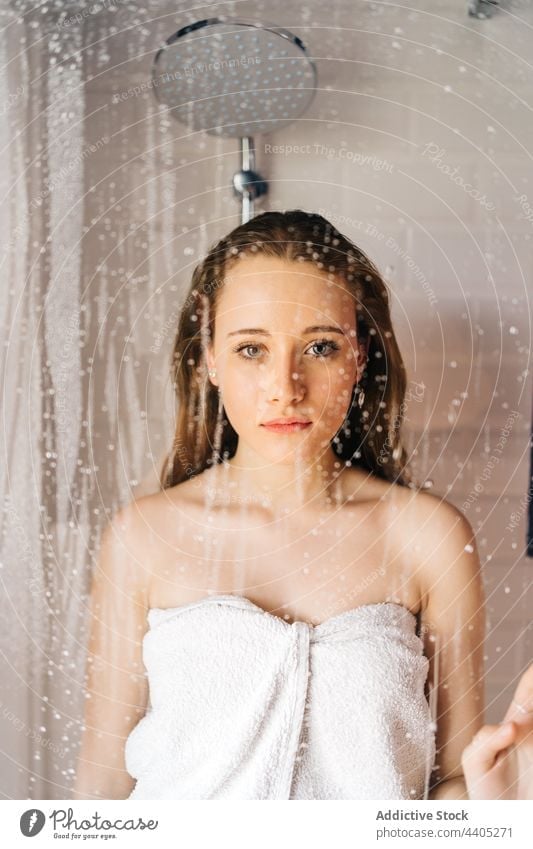 Woman standing behind glass wall of shower woman wet towel wrap cabin hygiene bathroom female young care clean water waterdrop droplet pure soft fresh skin care