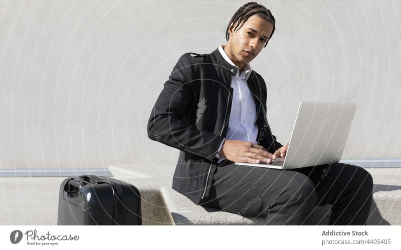Man with braids using laptop on street man freelance urban style typing remote black digital african american businessman work gadget device male hairstyle