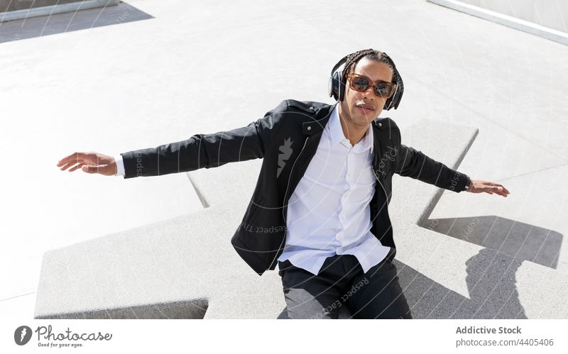 Happy businessman in headphones and sunglasses on street style happy trendy music enjoy urban carefree young ethnic braid african american black fashion modern
