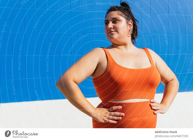 Plus size ethnic sportswoman with hands on waist athlete hand on waist healthy lifestyle vitality wellness self assured plump street energy overweight confident