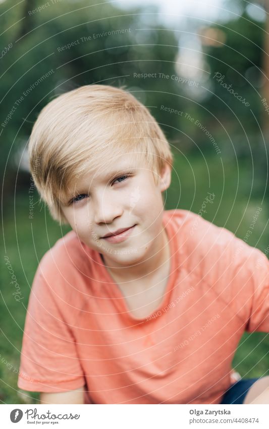 Smiling boy looking at the camera outdoors. portrait teenage blond smile midsection cute caucasian children joy happy young summer looking at camera positive