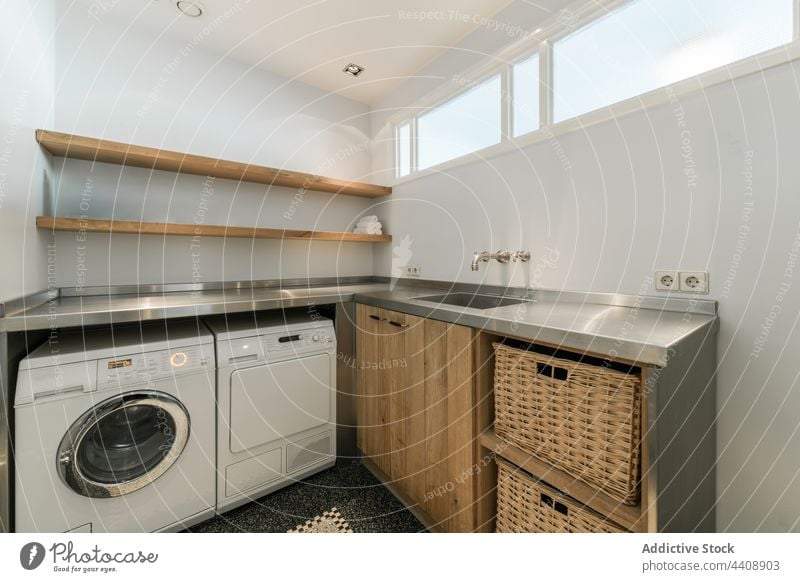 Laundry room with washing machine laundry interior design home modern domestic style corner contemporary equipment counter sink tap basket small furniture