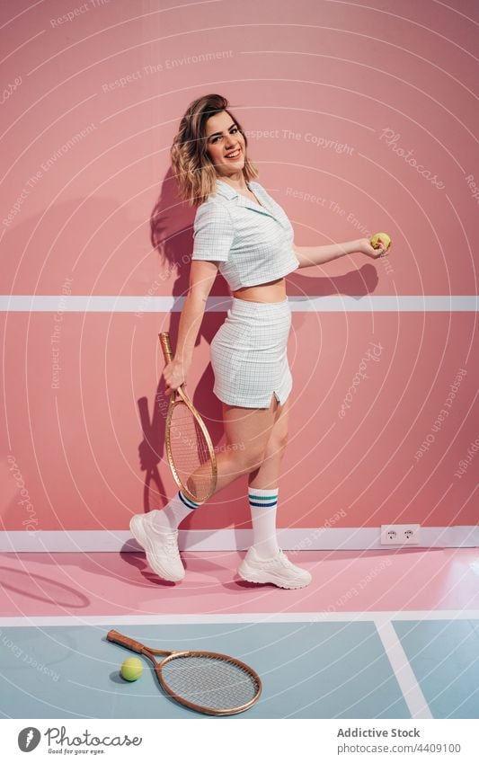 Smiling player with tennis racket and ball on court cheerful sport style active woman portrait energy sportswoman sportswear knee sock fit modern sneakers smile