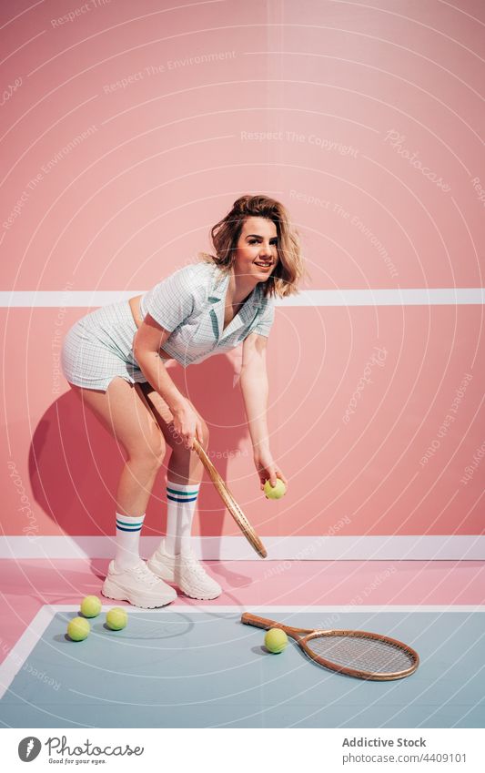 Smiling player with tennis racket and ball on court cheerful sport style active woman portrait energy sportswoman sportswear knee sock fit modern sneakers smile