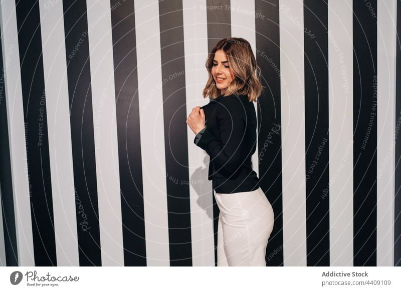 Sensual model in stylish jacket on striped background fashion style sensual seductive trousers contrast woman portrait breast pants provocative trendy black