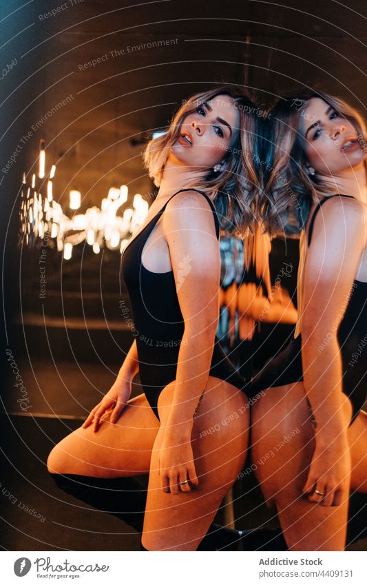 Sensual model in bodysuit reflecting in mirrors sensual beauty natural reflection woman lamp lingerie underwear curve feminine hand behind head black color