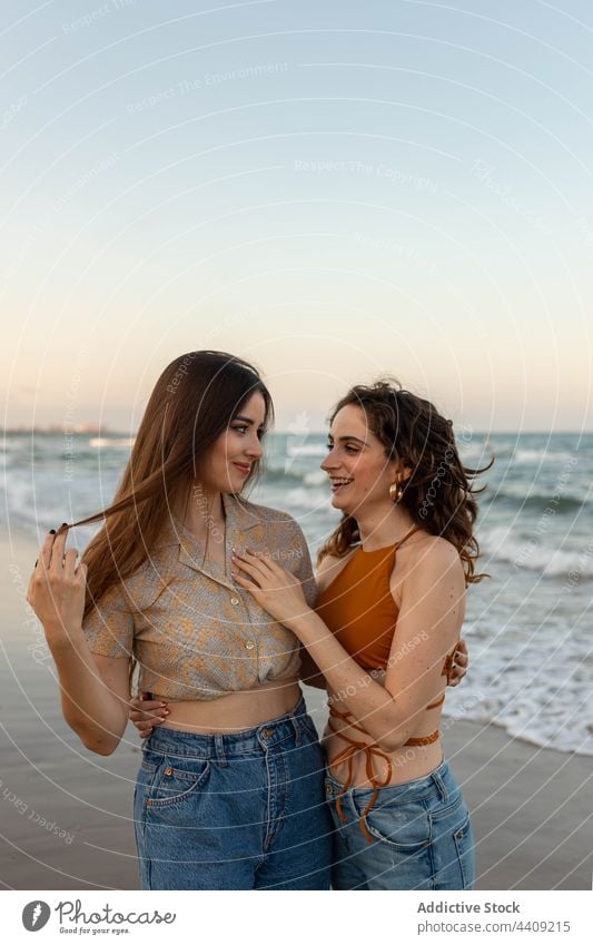 Lesbian couple embracing on beach women lesbian sea sundown hug love date female girlfriend romantic together sunset coast embrace relationship vacation summer