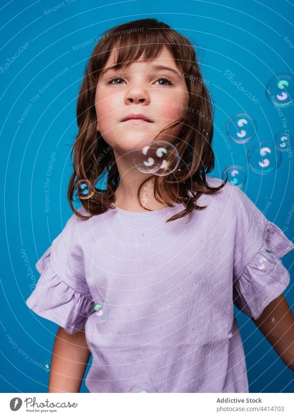 Cheerful preteen girl standing in studio with soap bubbles child carefree move freedom having fun kid cheerful joy bright enjoy creative fly float active