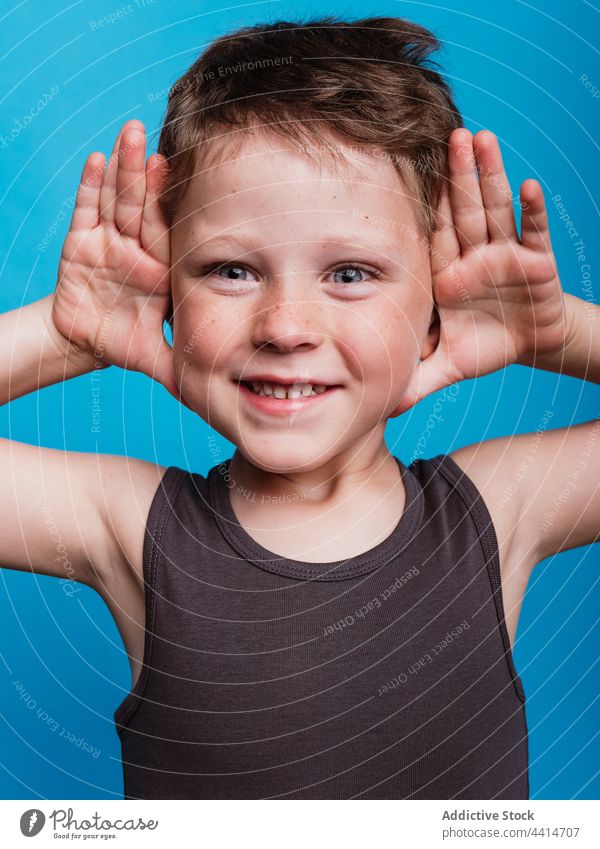 Delighted child with open palms near face in studio happy face expression cheerful boy joy kid preteen glad optimist smile childhood positive excited fun