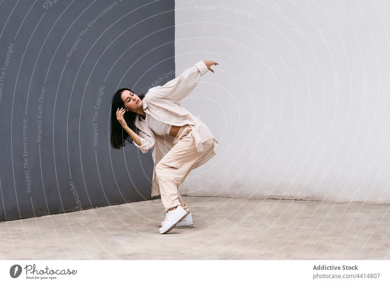 Flexible woman dancing near grey and white wall in city dance dancer perform street flexible choreography move female grace talent urban lean skill style energy