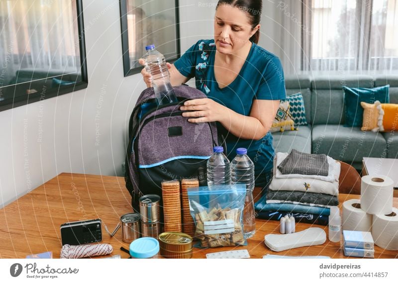 https://www.photocase.com/photos/4414857-woman-putting-a-water-bottle-to-prepare-emergency-backpack-photocase-stock-photo-large.jpeg